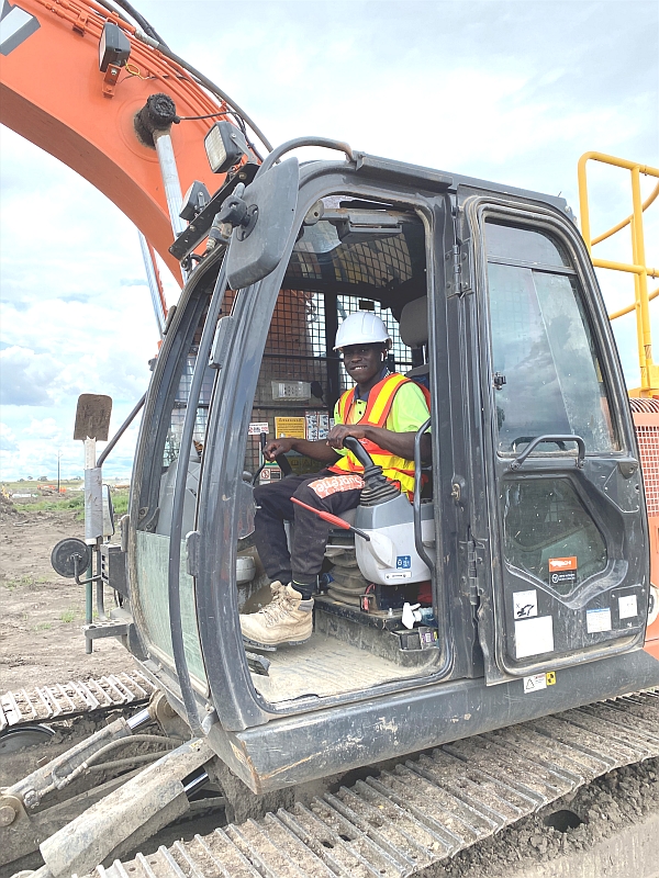 Afrime in excavator with dozer blade during worksite visit as part of Prace's Civil Construction Labourer course.