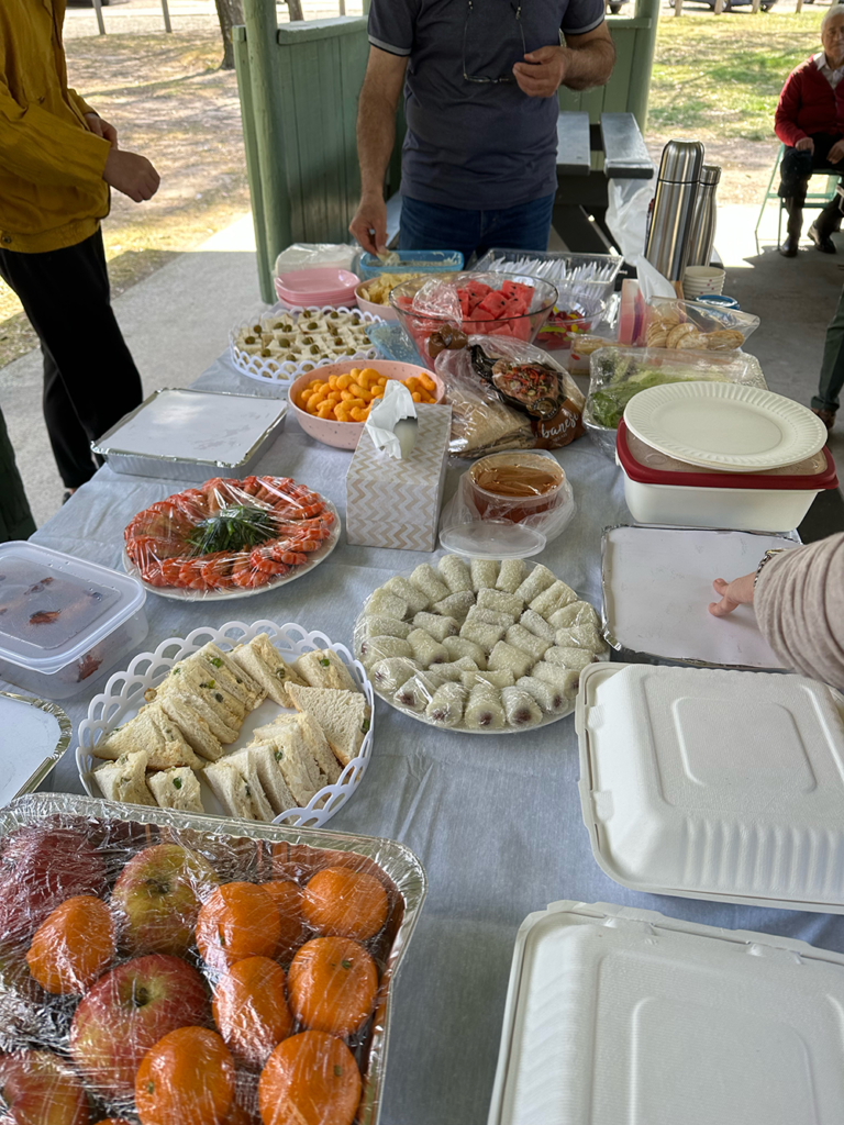 A picnic table laid out with food from many cultures.