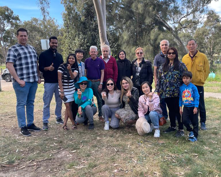 A group of Prace EAL students posed in the parklands at Bundoora Homestead.